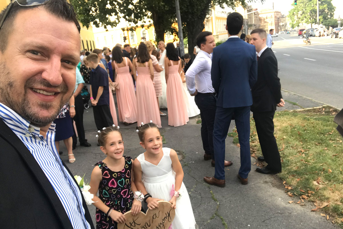 Kiss Levente ceremóniamester a koszorúslányokkal, „Itt jön a menyasszony” táblával